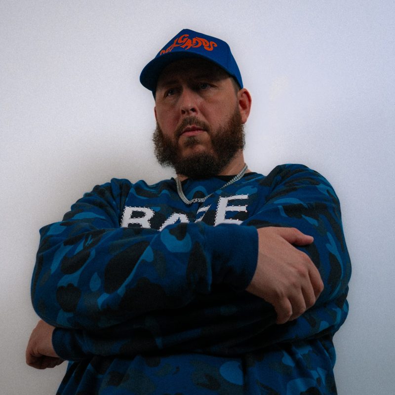 Fenix with his arms crossed in a blue camo sweatshirt